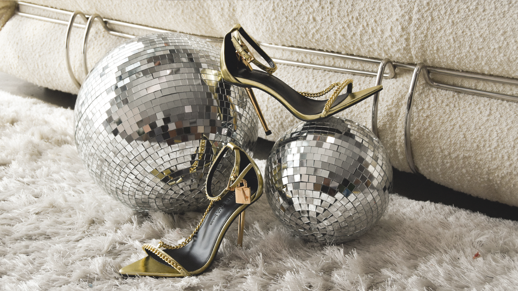 Shag carpet and disco ball setting with gold stiletto chain and lock detail heels  